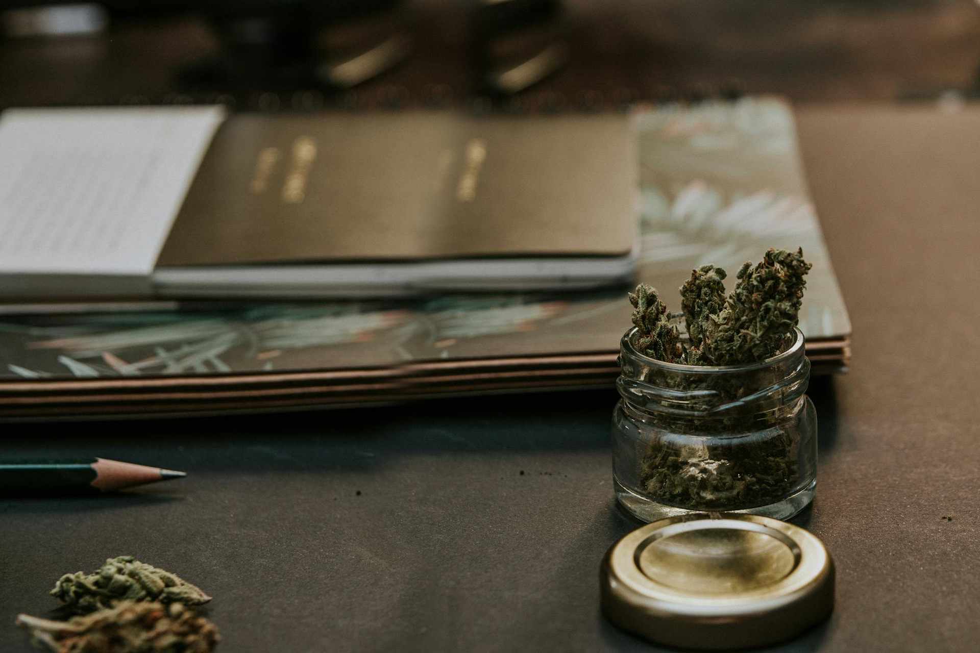 Jar of cannabis buds on desk
